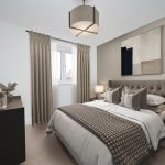 Modern bedroom with beige decor and large window.