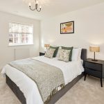 Modern bedroom with double bed and bedside lamps.