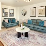 Modern living room with blue sofas and art prints.