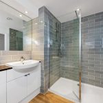 Modern bathroom with grey tiles and glass shower