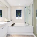 Modern bathroom with plants and glass shower door.