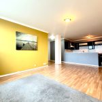 Spacious living room with wooden flooring and kitchen.