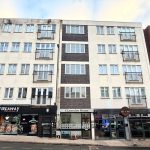 Street view of Clarendon House apartments and shops.