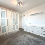 Spacious wardrobe and drawers in modern bedroom.