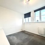 Empty room with carpet and large windows.