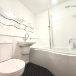 Modern bathroom with curved bathtub and wavy mirror