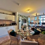 Modern open-plan kitchen and living area with decor.