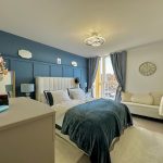 Modern bedroom with blue accents and wall clock.