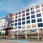 Modern office building with glass windows and parking.