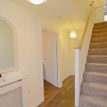 Modern hallway with staircase and ambient lighting.