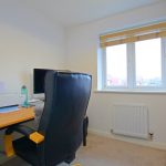 Home office with desk, chair, and window view.
