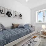 Cosy bedroom with single bed and wall art.