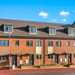 Modern three-storey brick houses with dormer windows.