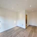 Empty room with wooden floor and white walls.