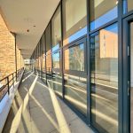 Modern building with glass windows and sunny reflections.