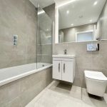 Modern bathroom with grey tiles and fittings.