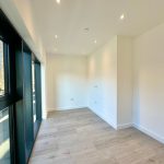 Modern empty room with wooden flooring.