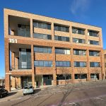 Modern brick office building with number 151 displayed