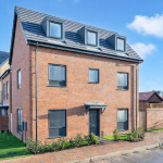 Modern suburban brick house with dormer windows.