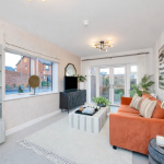 Modern living room with orange sofa and large window.