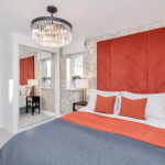 Modern bedroom with orange accents and mirrored wardrobe