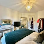 Cosy bedroom with modern decor and clothing rack.