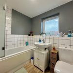Modern bathroom with grey walls and white tiles.
