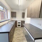 Modern kitchen with grey worktops and cupboards.