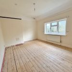 Empty room with wooden floor and large window