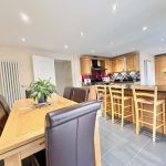 Modern kitchen and dining area with wooden furniture.