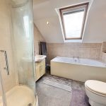 Modern bathroom with skylight and corner shower.