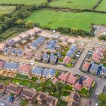 Aerial view of houses under construction in countryside.