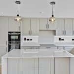 Modern grey kitchen with island and pendant lights.