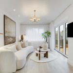 Modern living room with cosy white sofa, large window.