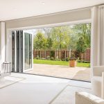 Modern living room with open bi-fold doors to garden.