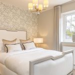 Elegant bedroom with patterned wallpaper and cosy bed.