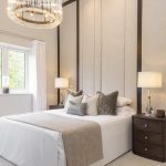 Modern bedroom with elegant decor and chandelier.