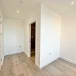Minimalist room with wooden floor and white walls.