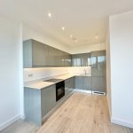 Modern grey kitchen with wood flooring, UK style.