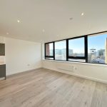 Spacious modern apartment with large windows and city view.