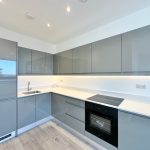 Modern kitchen with grey cabinets and appliances.