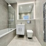 Modern bathroom with grey tiles and fixtures.