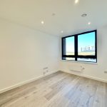 Empty bright room with wooden floor and large window.