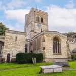 Historic church with clock tower and graves.