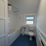 Simple white bathroom with bathtub and toilet