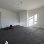 Empty room with carpet and vacuum cleaner