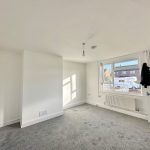 Bright empty room with window and door open.