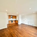 Spacious apartment with wooden flooring and modern kitchen.