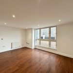Spacious room with wooden floor and large windows