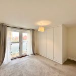 Bright room with French doors and wardrobe.
